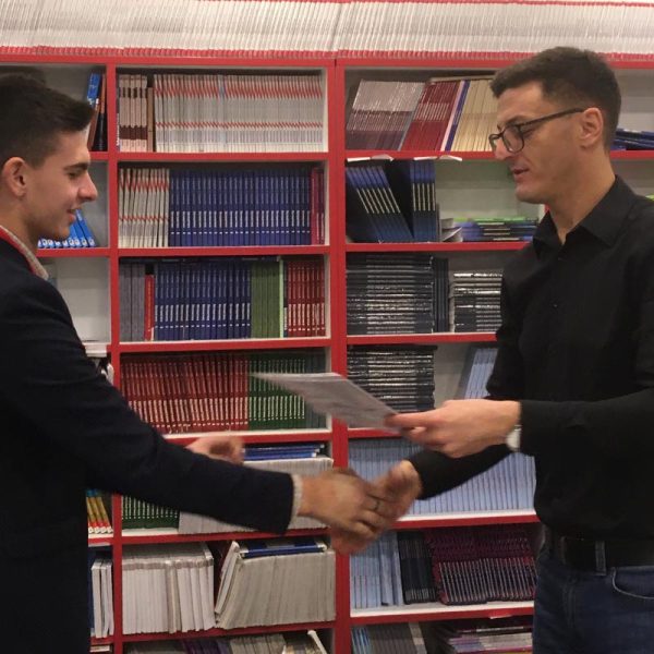 Profesor uručuje diplomu učeniku