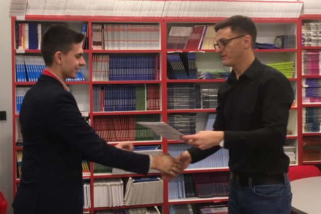 Profesor uručuje diplomu učeniku