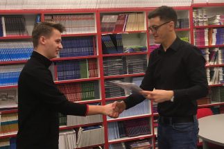 Profesor dodeljuje diplomu učeniku