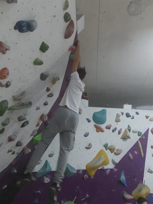Učenik se penje na veštačku stenu